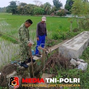 Pastikan Air Mengalir ke Sawah, Babinsa Tanah Pasir Dampingi Petani Pantau Pintu Irigasi